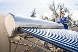 Male Plumber Doing Solar Energy Boiler Inspection