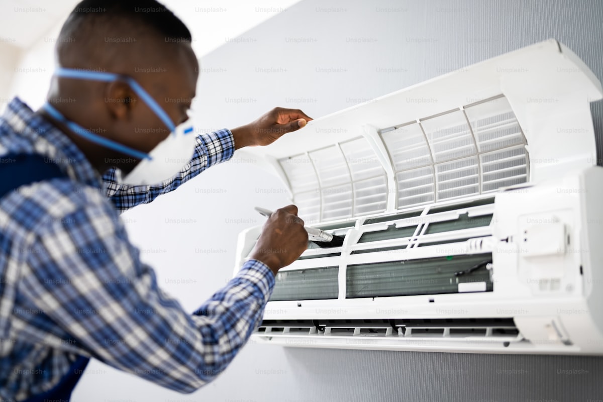 HVAC technician checking and maintaining an air conditioning unit