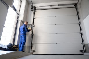 Installation et réparation de portes de garage à la maison. Entrepreneur Man In House