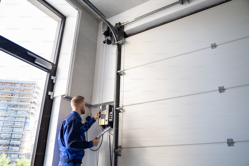 Garage Door Installation And Repair At Home. Contractor Man In House