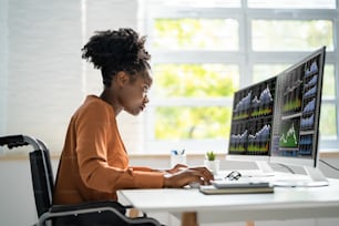 Stock Market Analyst At Office Desk Using Multiple Screens