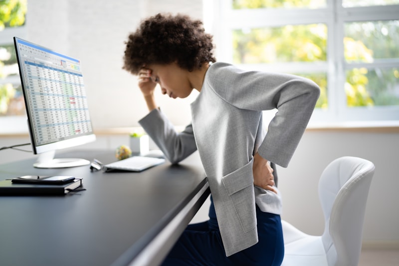 Femme souffrant de douleurs cervicales au bureau