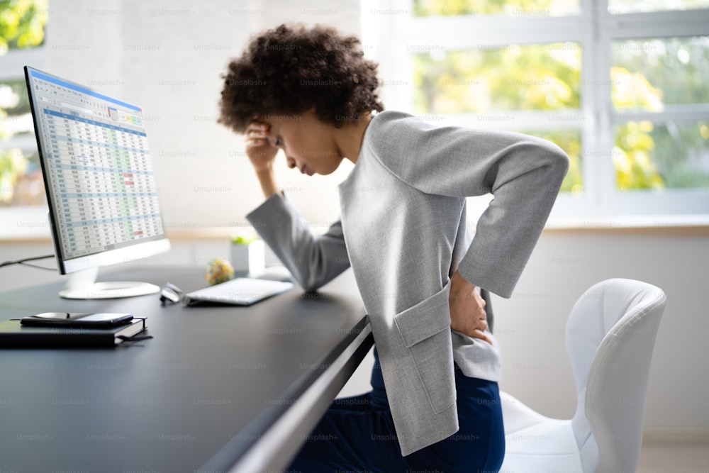 Rückenschmerzen schlechte Haltung Frau sitzt im Büro