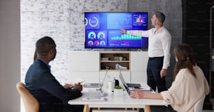 Businesspeople Looking At Businessman Giving Presentation In Meeting