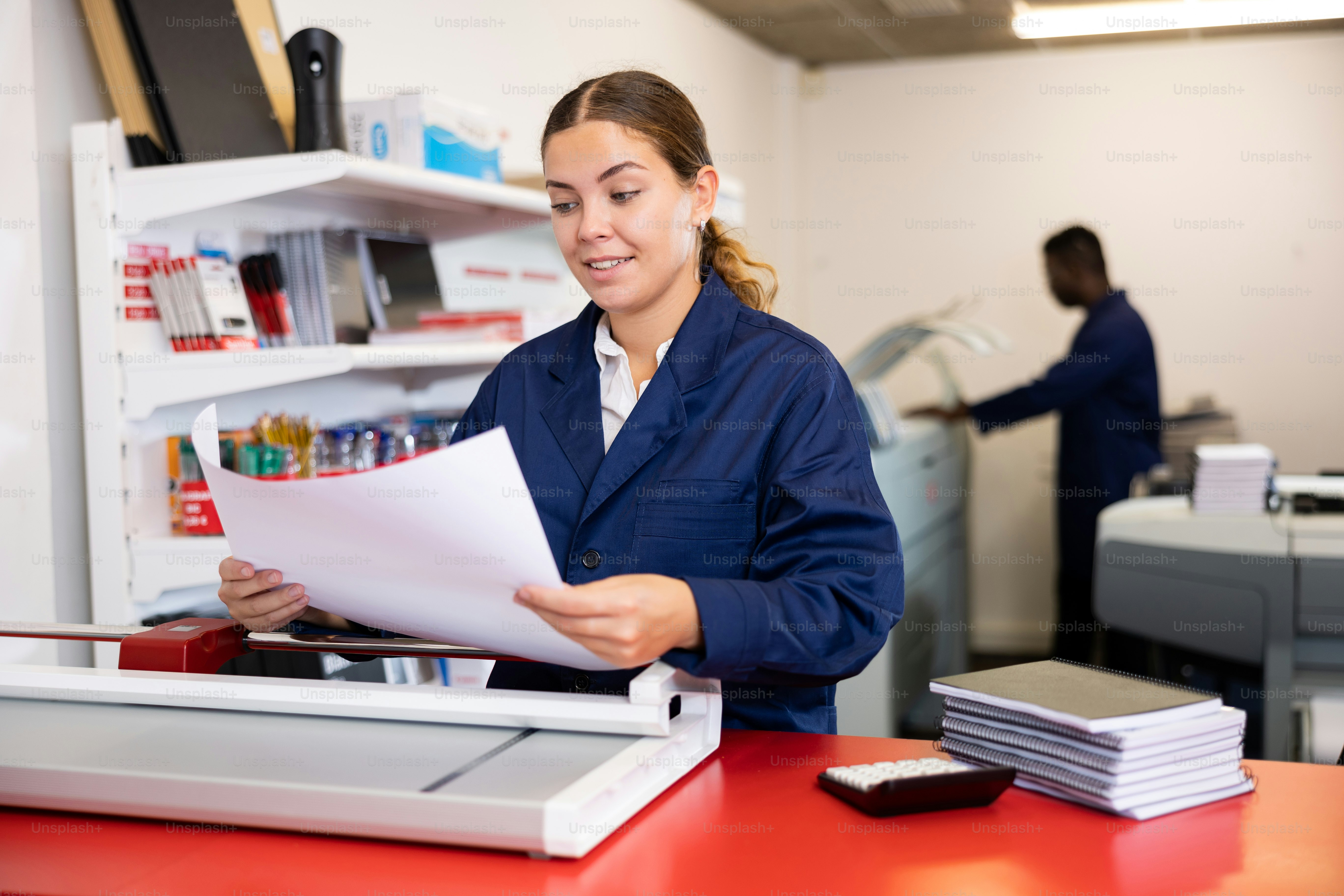 Portrait of an attentive woman checking quality of printing in a printing house