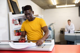 Employee of printing house checks the quality of printing in the computer room