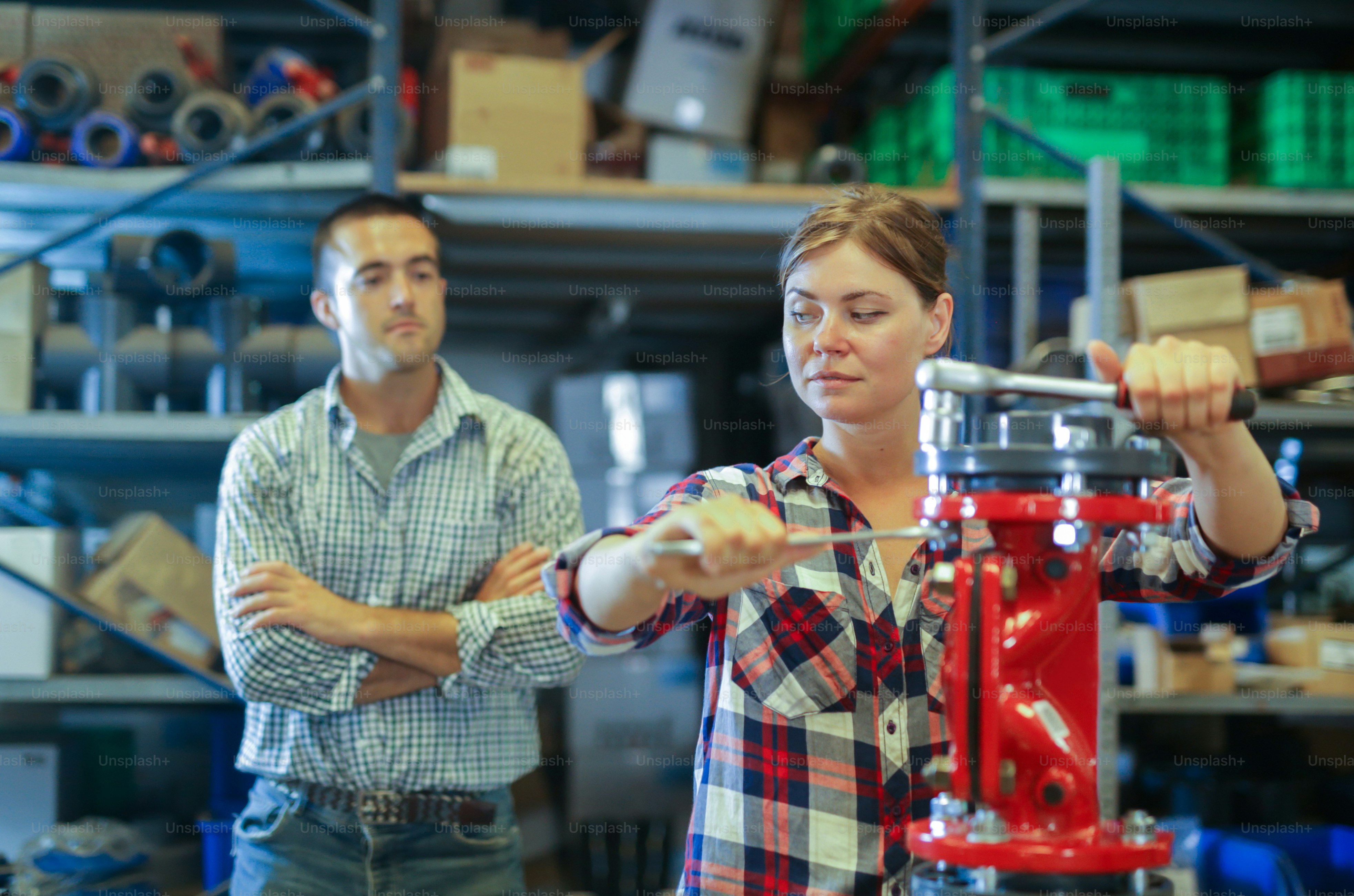 Female worker manually assembles shut-off valves under the guidance and ...