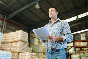Man inspecting warehouse to check quantity of goods on shelves. Man examining storehouse.