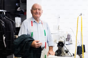 Retrato de un sastre anciano consumado en su lugar de trabajo en un taller de costura