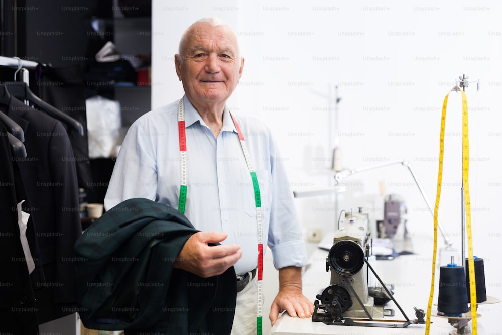 Retrato de un sastre anciano consumado en su lugar de trabajo en un taller de costura