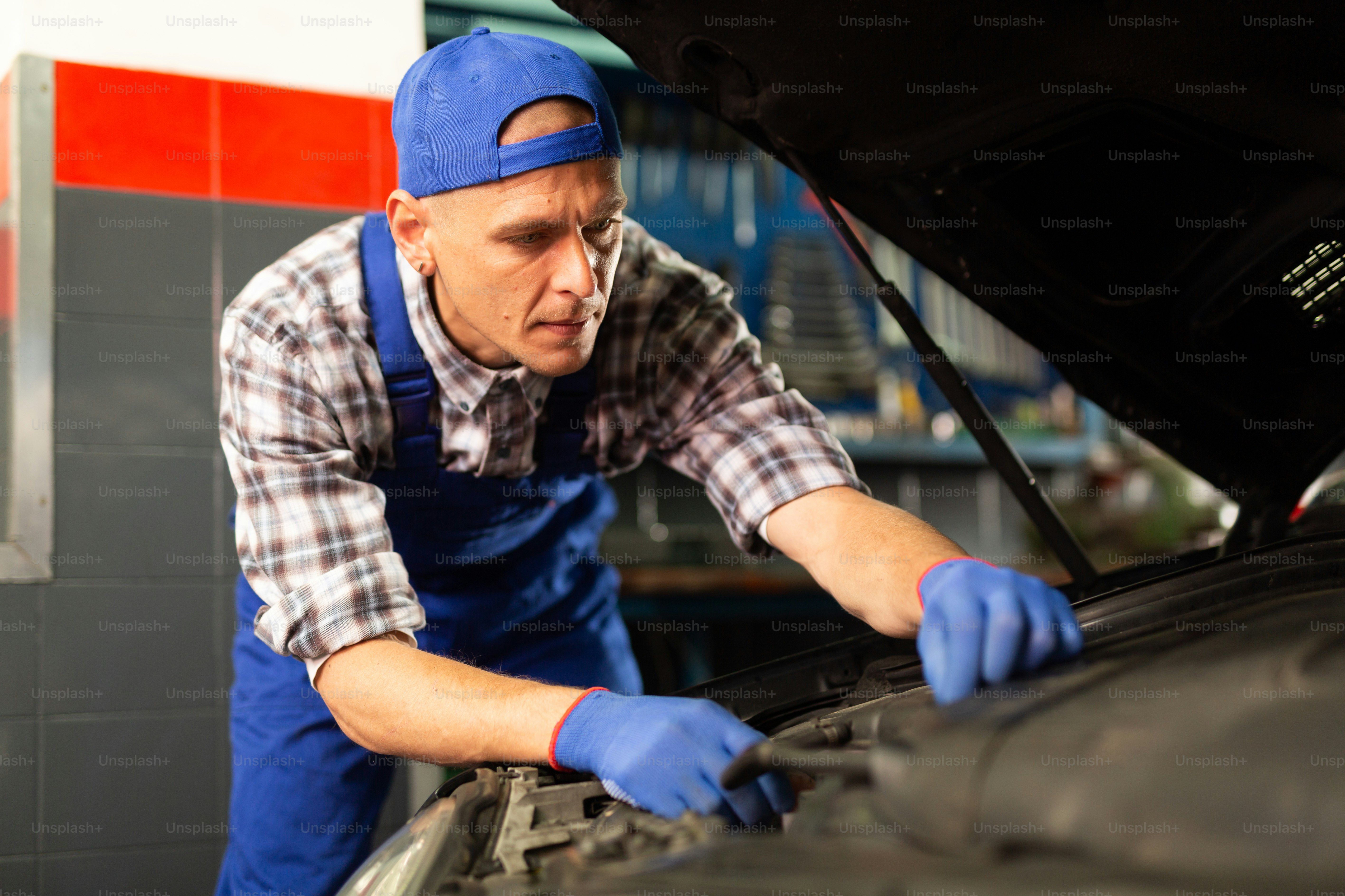 Mechanic technician working at service station, repairing car