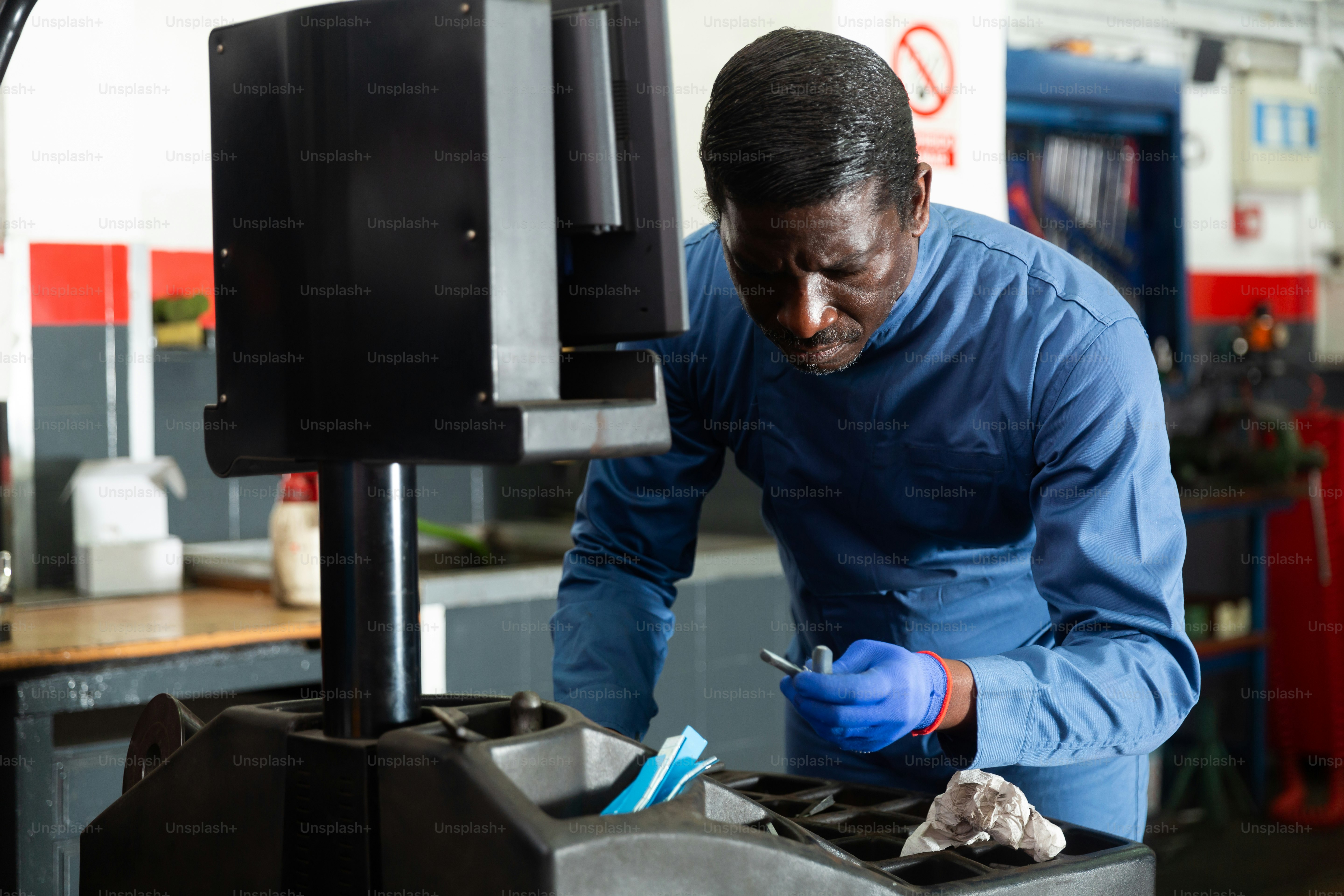 Mechanic balancing tire in auto repair shop using a computer