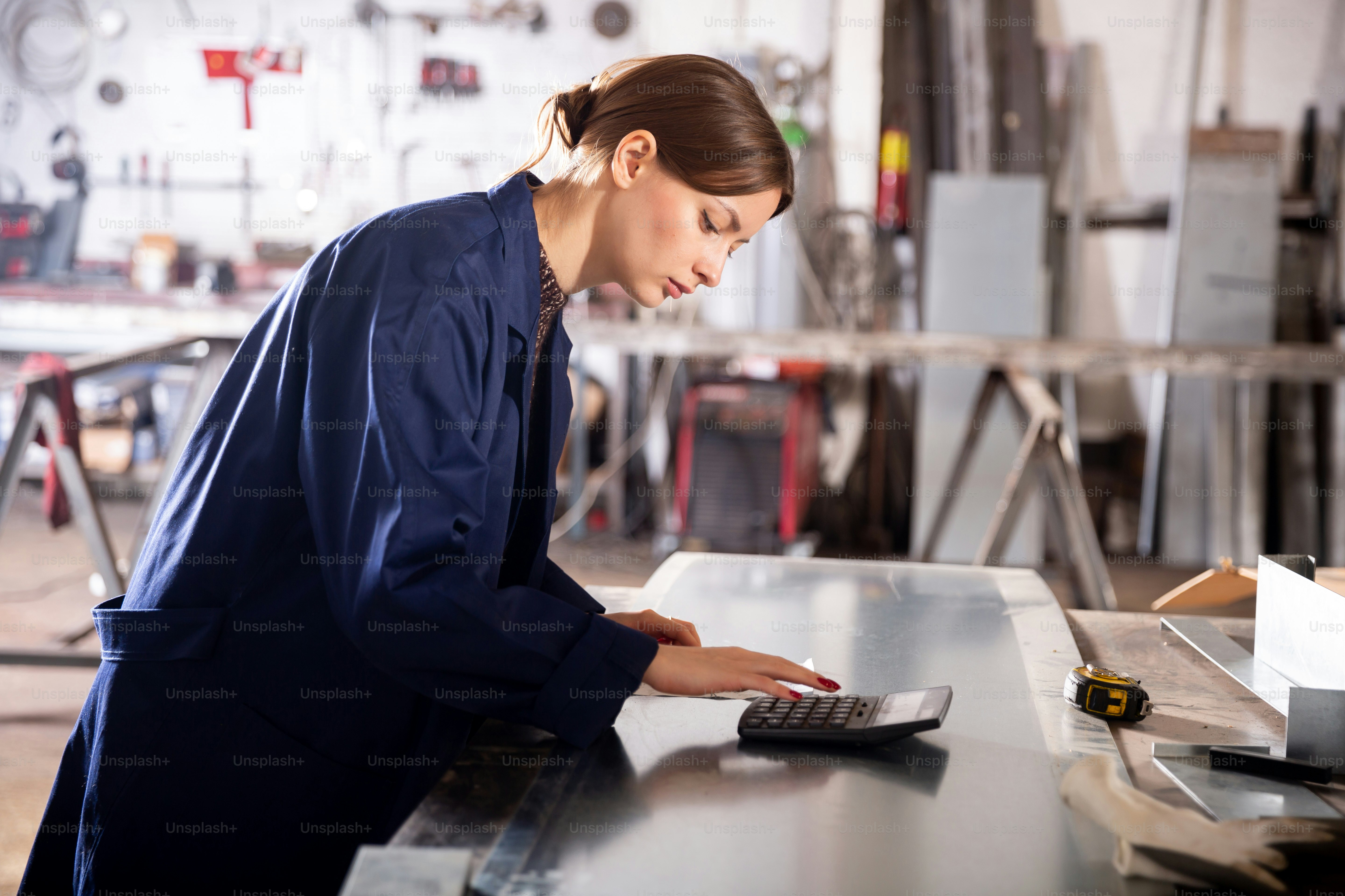 Junge Ingenieurin Materialkostenkalkulation in der Werkstatt