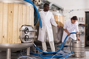 Portrait of brewers working on his workplace in the brew-house