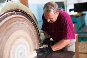 Arbeiter schleift Holzklötze auf Schleifmaschine