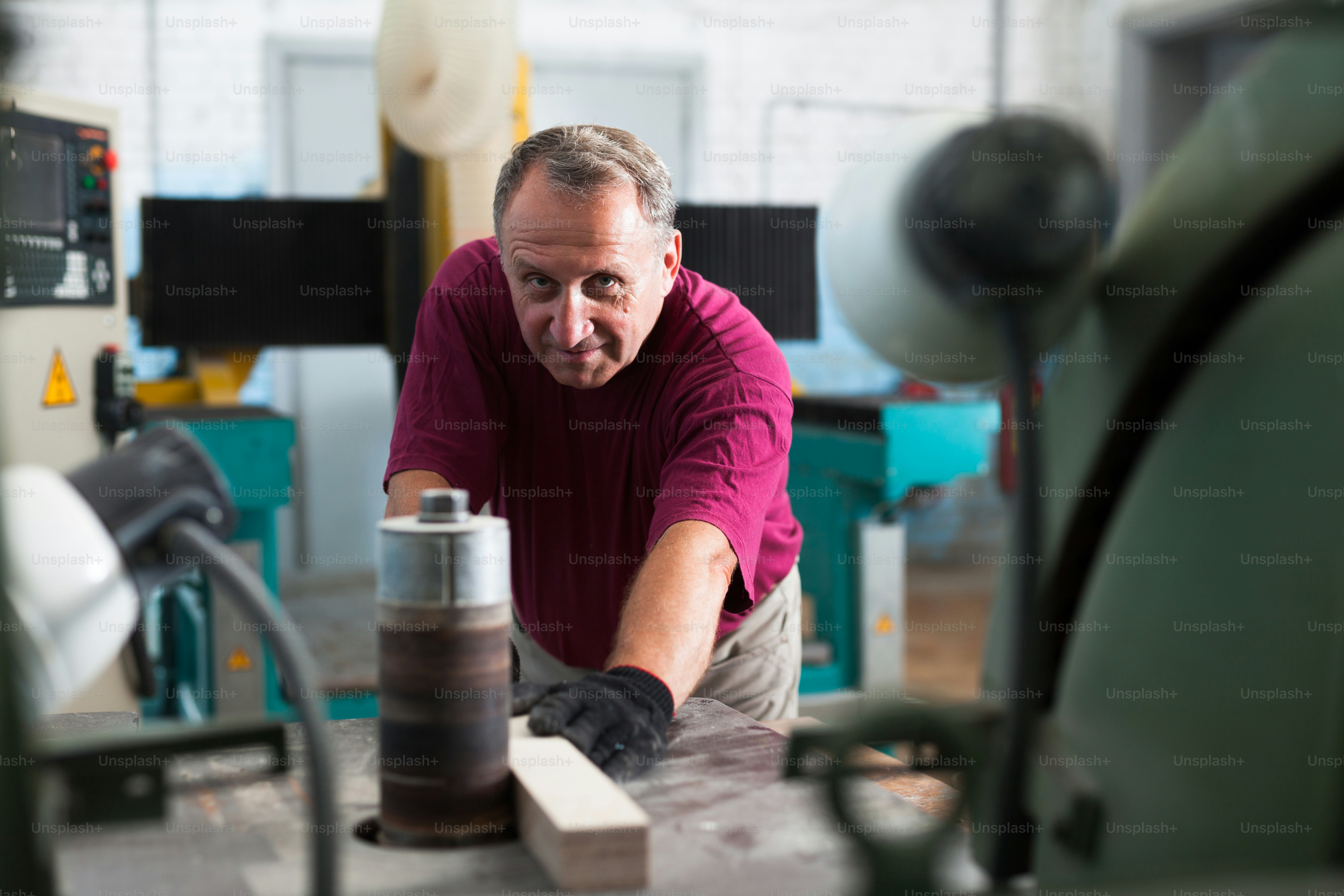 Positiver Handwerker bei der Arbeit an einer Dickenmaschine