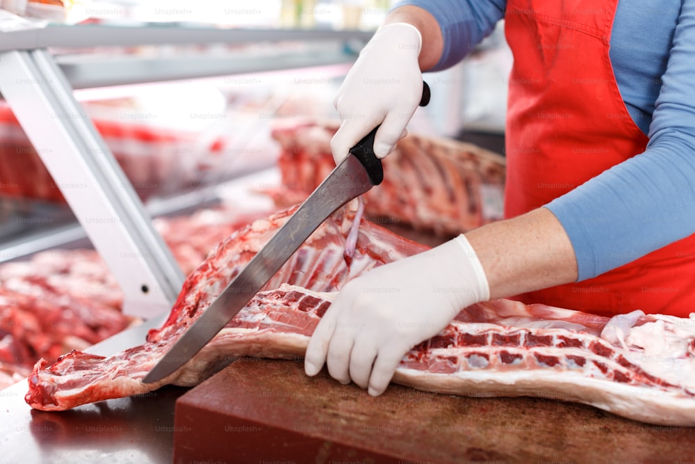 Primer plano de la carnicería cortando cerdos de calidad en carnicería