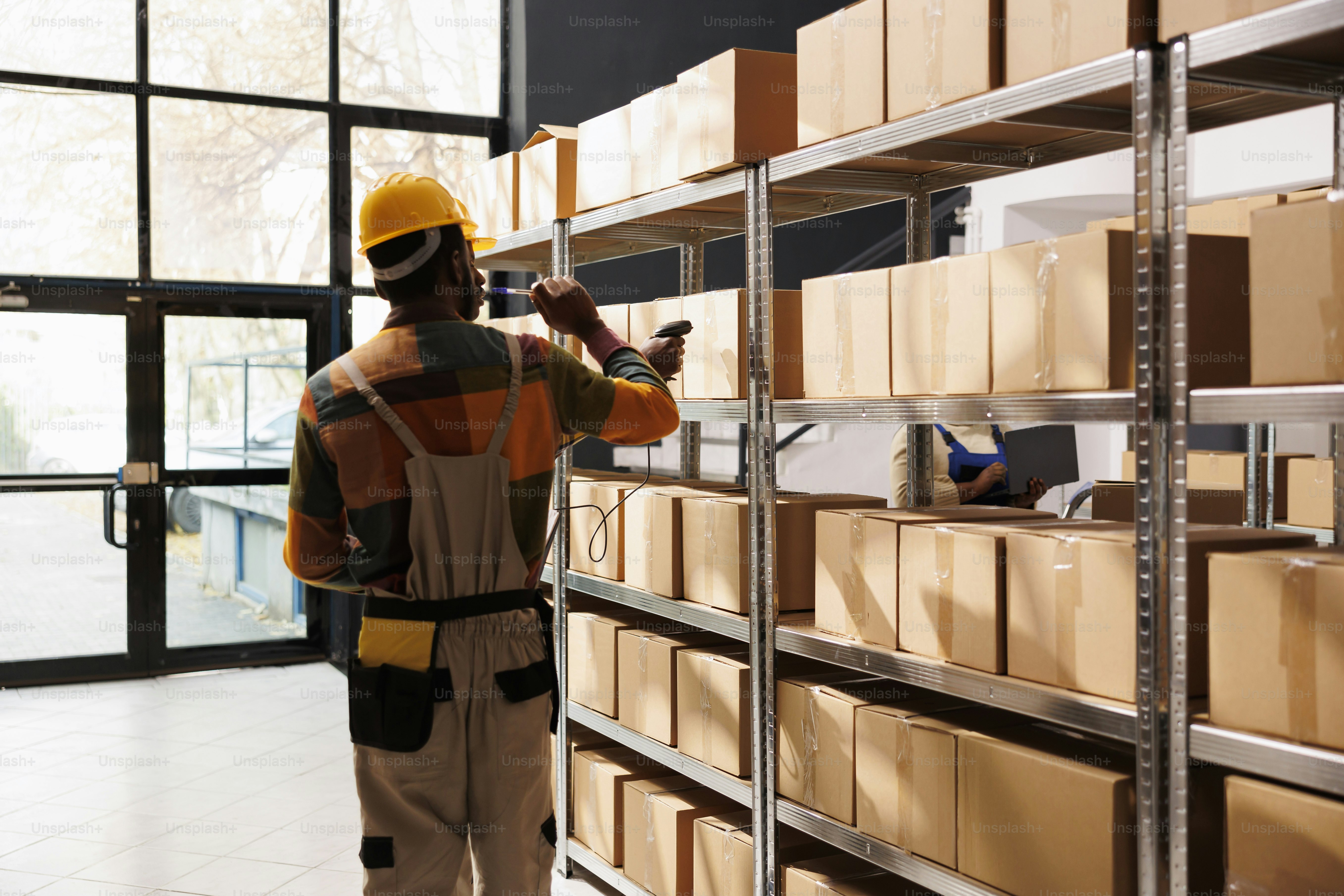 Les responsables des services de livraison afro-américains scannent le code-barres des colis avant l’expédition. Tous les travailleurs noirs de la compagnie maritime utilisent un scanner sur des boîtes en carton dans l’entrepôt