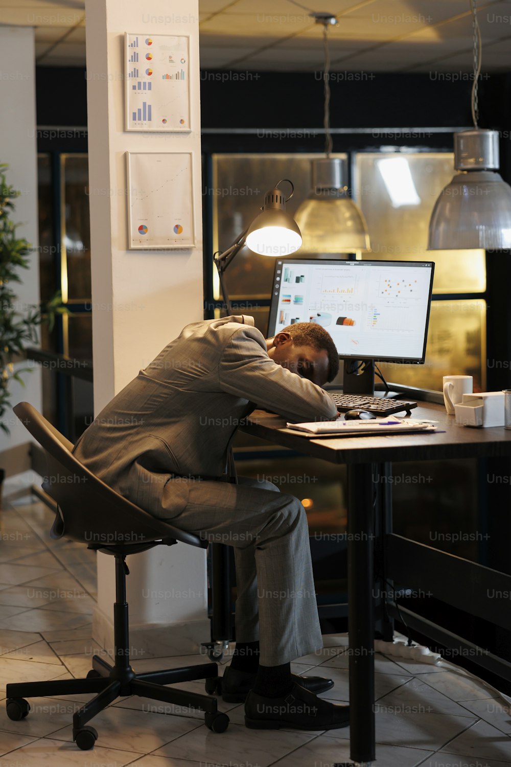 Exhausted overworked executive manager sleeping on desk table in startup office after planning company investment plan late at night. Workaholic entrepreneur working at marketing project.