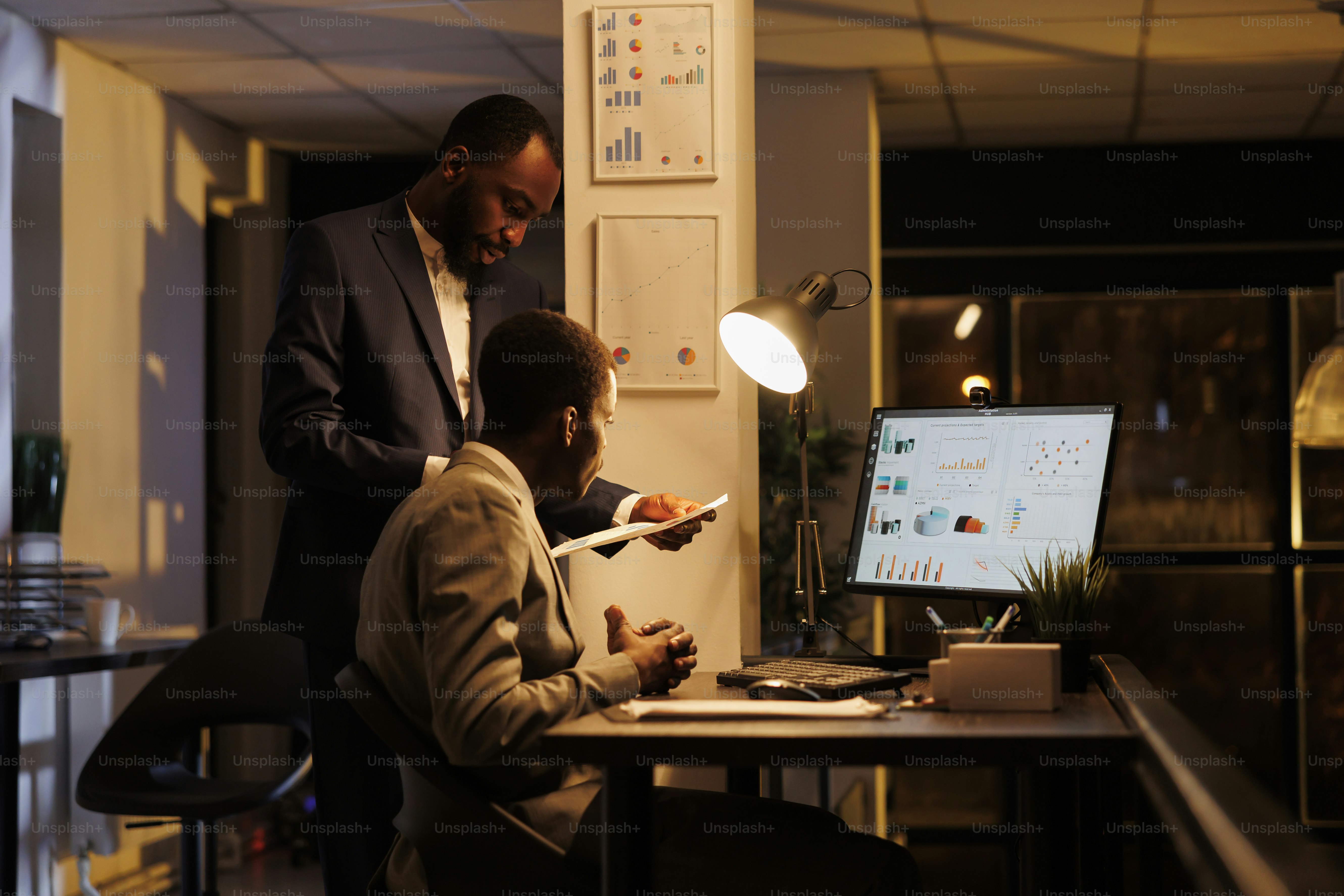 Corporate workers analyzing financial graphs report discussing company strategy late at night in startup office. Executive managers working at investment plan to increase business profit