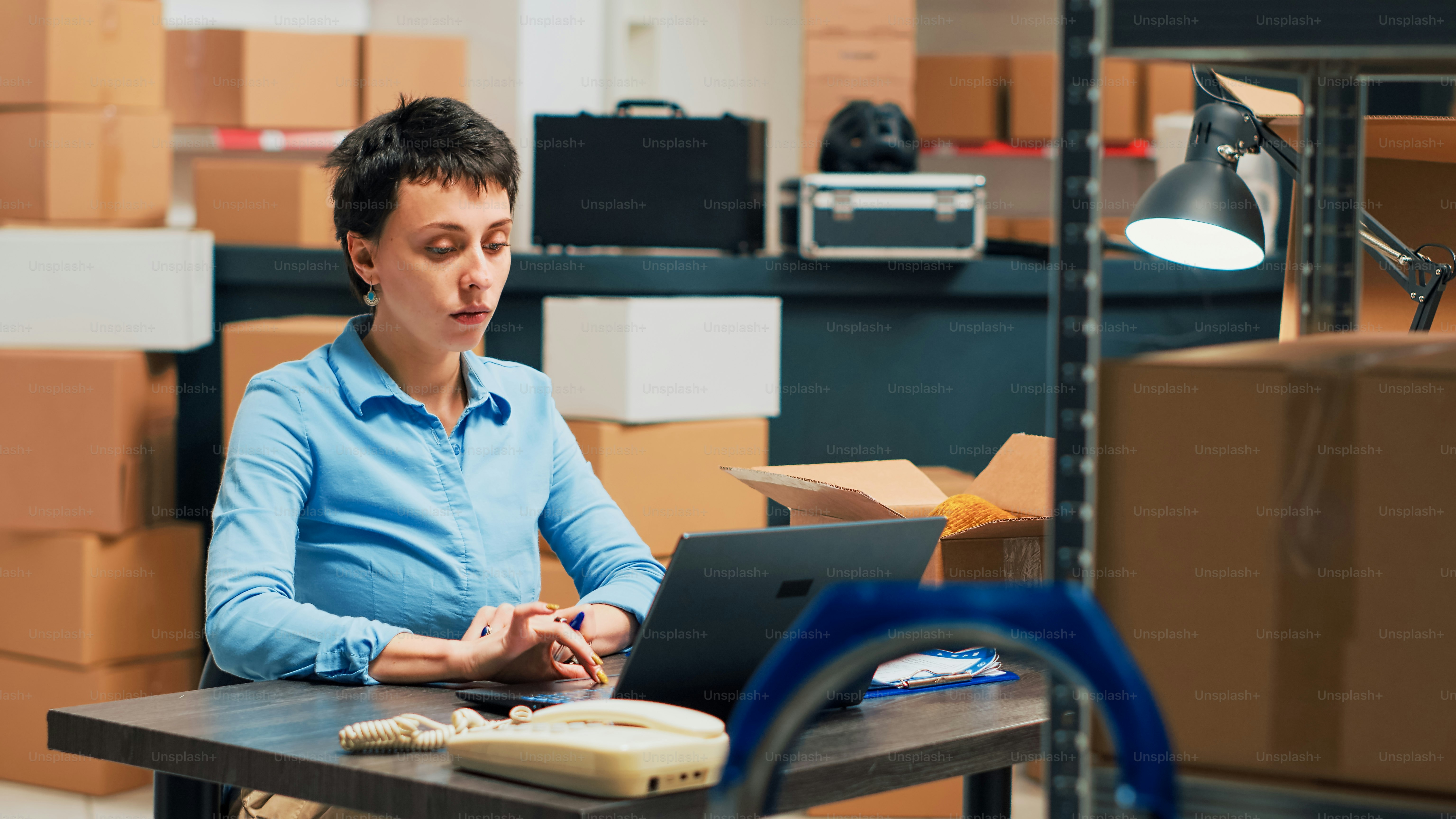 Unternehmer, der sich die Lieferungen in Kartons ansieht, bevor er die Bestellung von Produkten an Kunden versendet, den Vertrieb überprüft und eine Qualitätskontrolle durchführt. Weibliche Mitarbeiterin, die den Versand aus dem Lager plant.