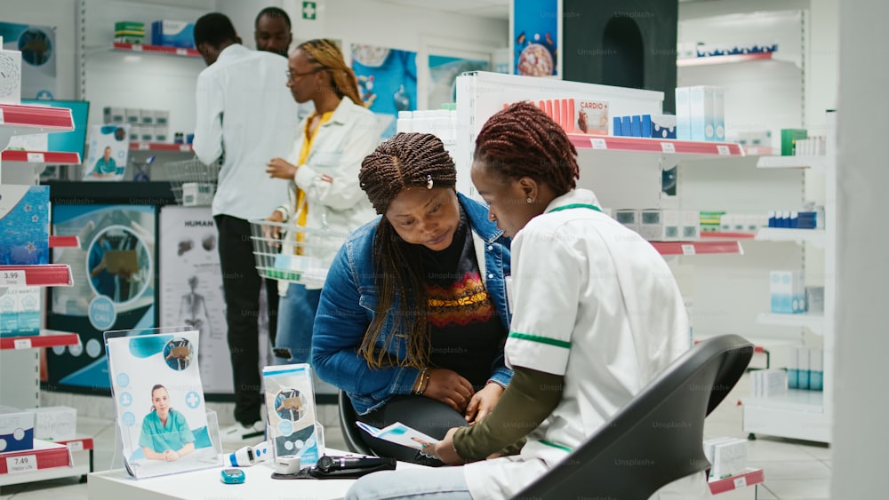 Mulheres afro-americanas verificando caixas de pílulas, cliente que procura comprar vitaminas e suplementos na farmácia. Farmacêutico e clientes que perguntam sobre medicamentos prescritos, farmacêuticos.