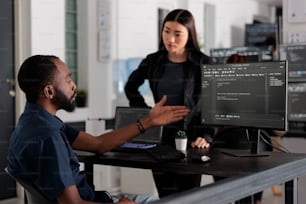 Équipe diversifiée de développeurs de logiciels développant du code html et du cloud computing dans l’agence de développement informatique. Ingénieur système afro-américain tapant sur le clavier pour créer un script d’intelligence artificielle.