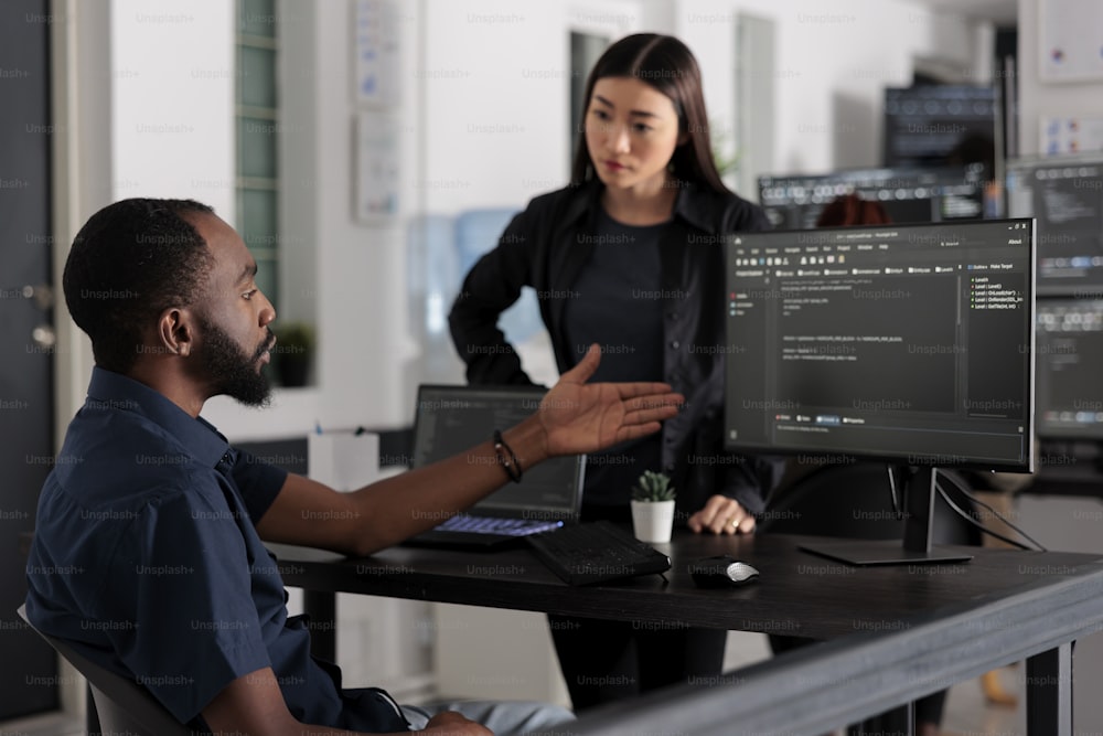Equipo diverso de desarrolladores de software desarrollando código html y computación en la nube en la agencia de desarrollo de TI. Ingeniero de sistemas afroamericano escribiendo en el teclado para crear un script de inteligencia artificial.