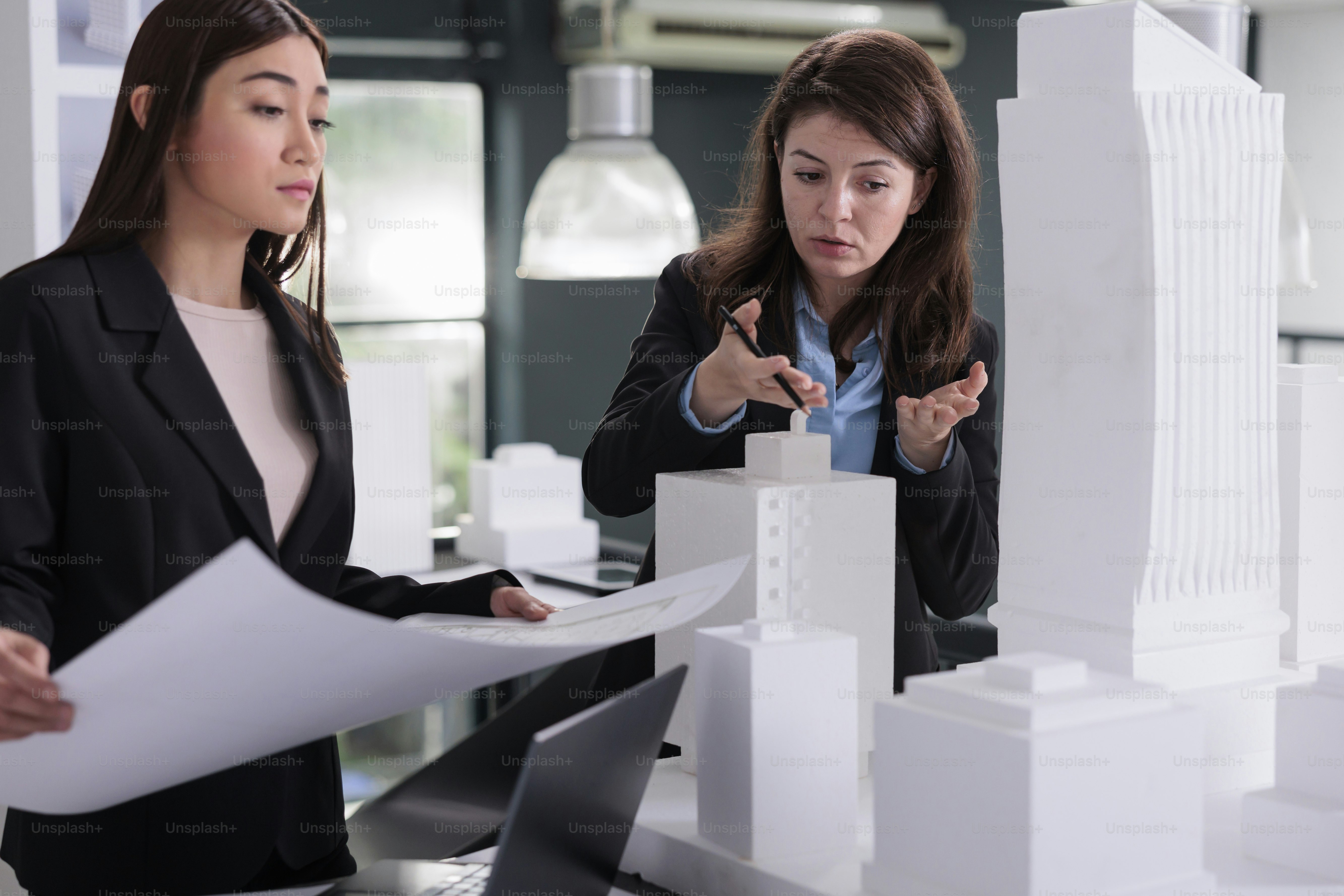 Architects teamwork, engineers discussing blueprint, holding building construction project draft, coworking in architecture office. Real estate agency workers talking about industrial sketch