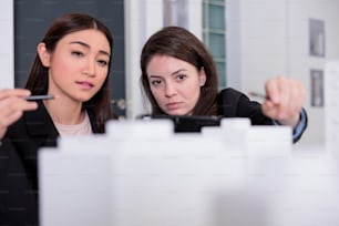 Les architectes discutent de la construction d’un modèle 3D imprimé, regardant le prototype dans l’espace de coworking, vue de face. Employés en bureau d’architecture orientation sélective, projet d’agence immobilière