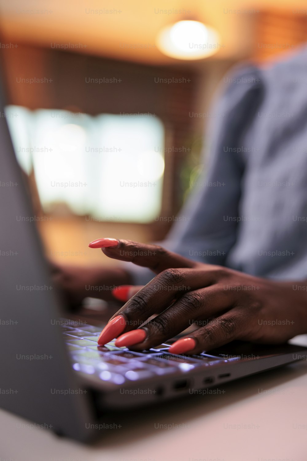 Young african american female freelancer typing on laptop keyboard, close view on hands. Businesswoman browsing internet, writing email on computer, focus on manicured nails