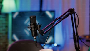 Selective focus on professional boom arm microphone stand used for recording voice in online podcast in home studio. Detail of sound device equipment used for live broadcast on internet.