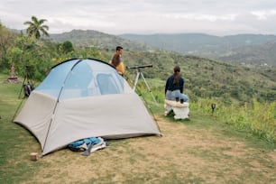 a couple of people standing next to a tent