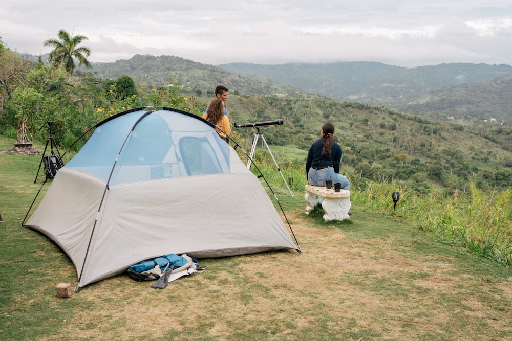 un couple de personnes debout à côté d’une tente