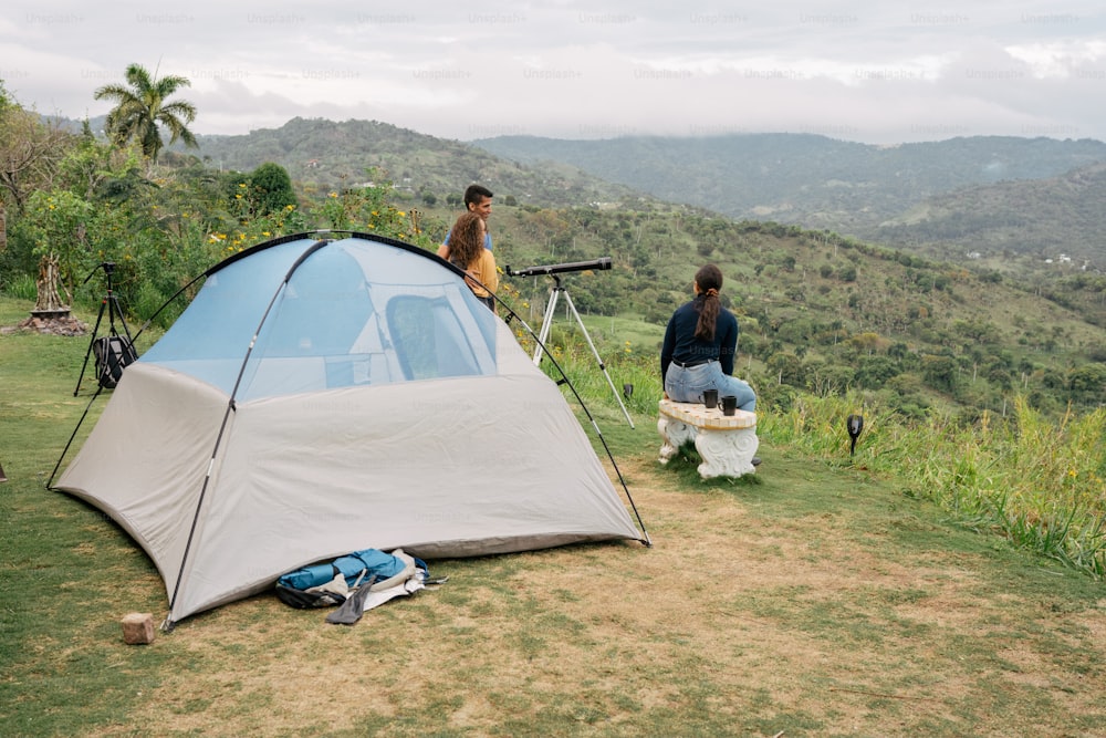 a couple of people standing next to a tent