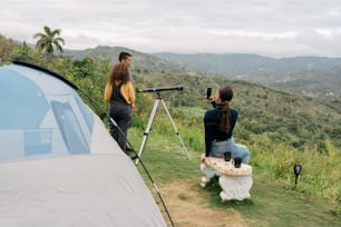 a couple of people sitting next to a tent