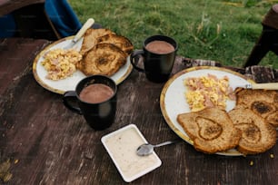 a wooden table topped with two plates of food