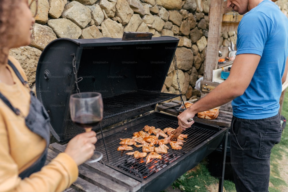 a man and a woman grilling food on a grill