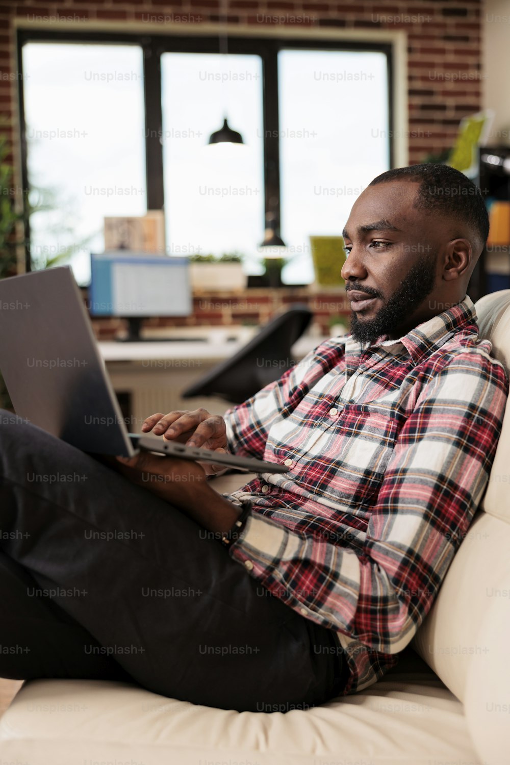 Empleado de oficina trabajando en una computadora portátil en casa, haciendo trabajo remoto y sentado en el sofá. Persona que usa la computadora para trabajar en la presentación de inicio con investigación de datos, enviando correo electrónico comercial.