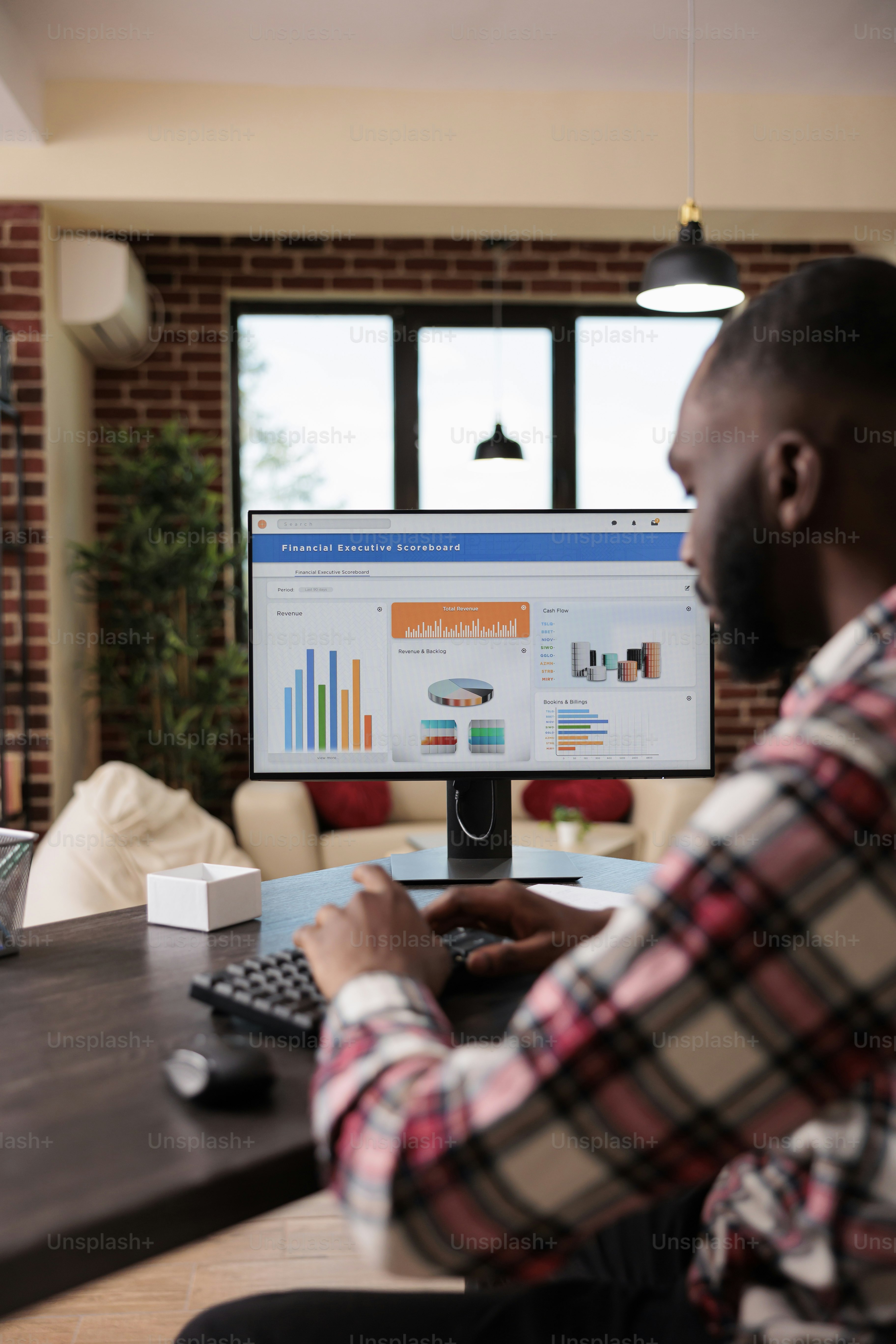 Young adult analyzing business charts on computer monitor, working with company diagrams and doing remote job. Office employee using research information and data to work remotely.