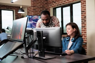 African american company coworker standing near production department team leader desk while discussing. Digital graphic artist with colleague talking about future of project.