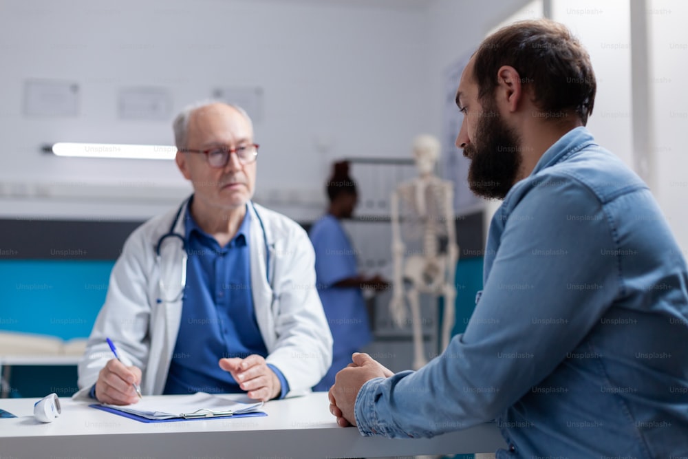 Specialist and person having conversation about diagnosis at checkup visit. Healthcare physician explaining treatment and medical support to patient, after medical consultation.