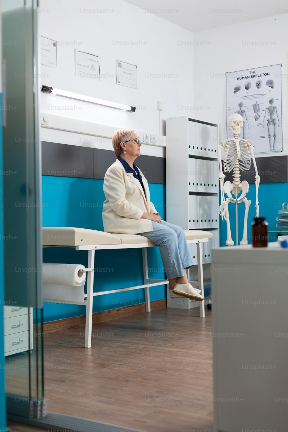 Paziente pensionata caucasica in piedi sul letto in attesa di trattamento farmacologico con appuntamento medico nell'ufficio dell'ospedale. Supporto ai servizi di medicina. Assistenza sanitaria