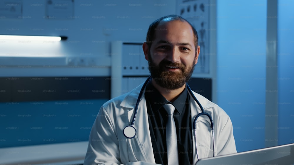 Physician doctor checking medical expertise on laptop computer working in hospital office late at night. General practitioner with stethoscope typing healthcare treatment. Medicine service and concept