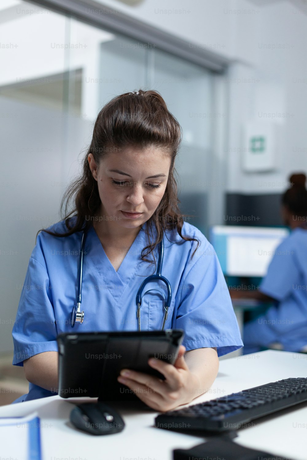 Practitioner nurse holding tablet computer analyzing sickness expertise working at healthcare treatment in hospital office. pediatrician asisstance checking pharmaceutical medication sitting at desk
