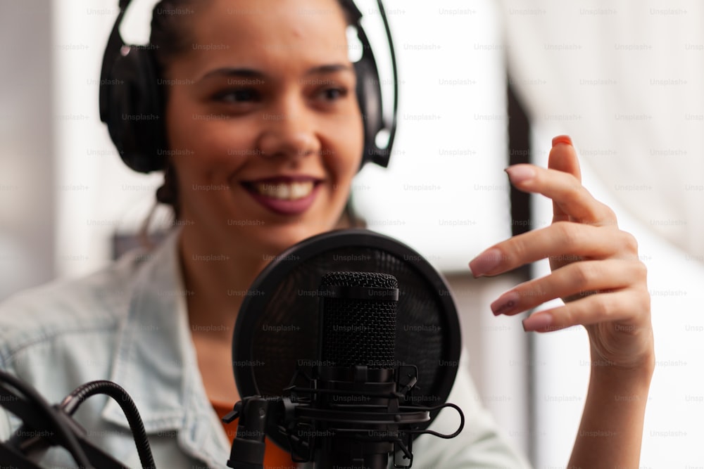 Close up of vlogger speaking at podcast microphone gesturing during life video vlog. Social media content creator recording fashion video for online channel sharing advices for followers community