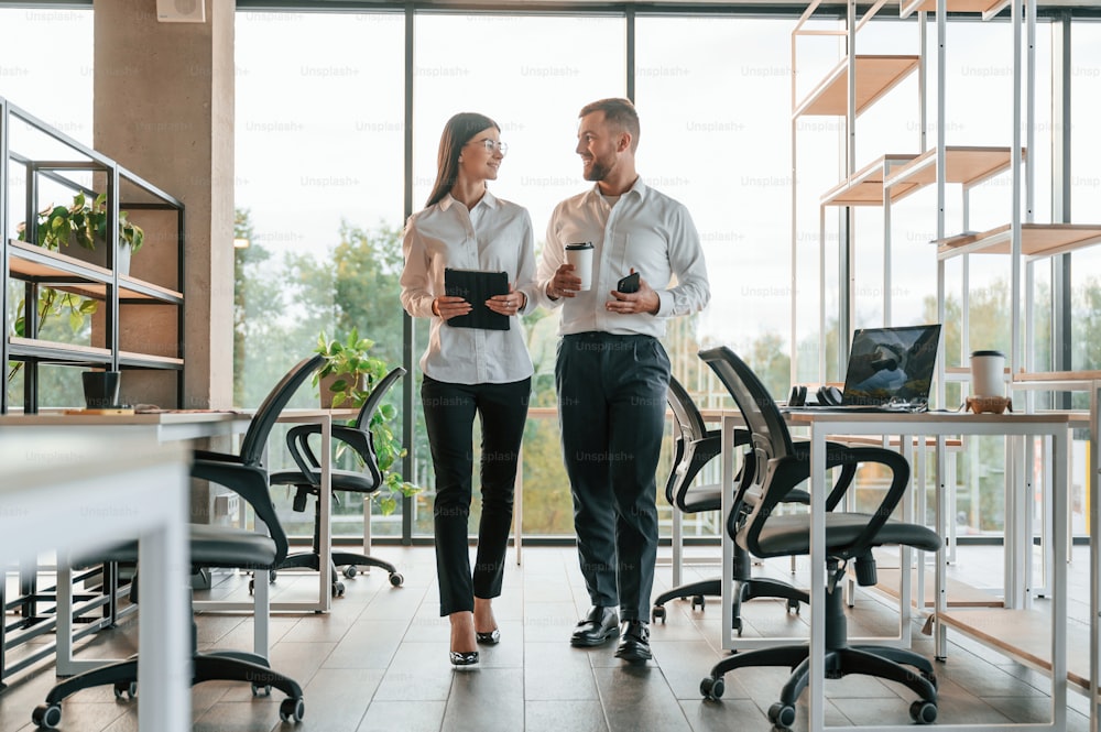 Front view. Man and woman are working in the modern office together.