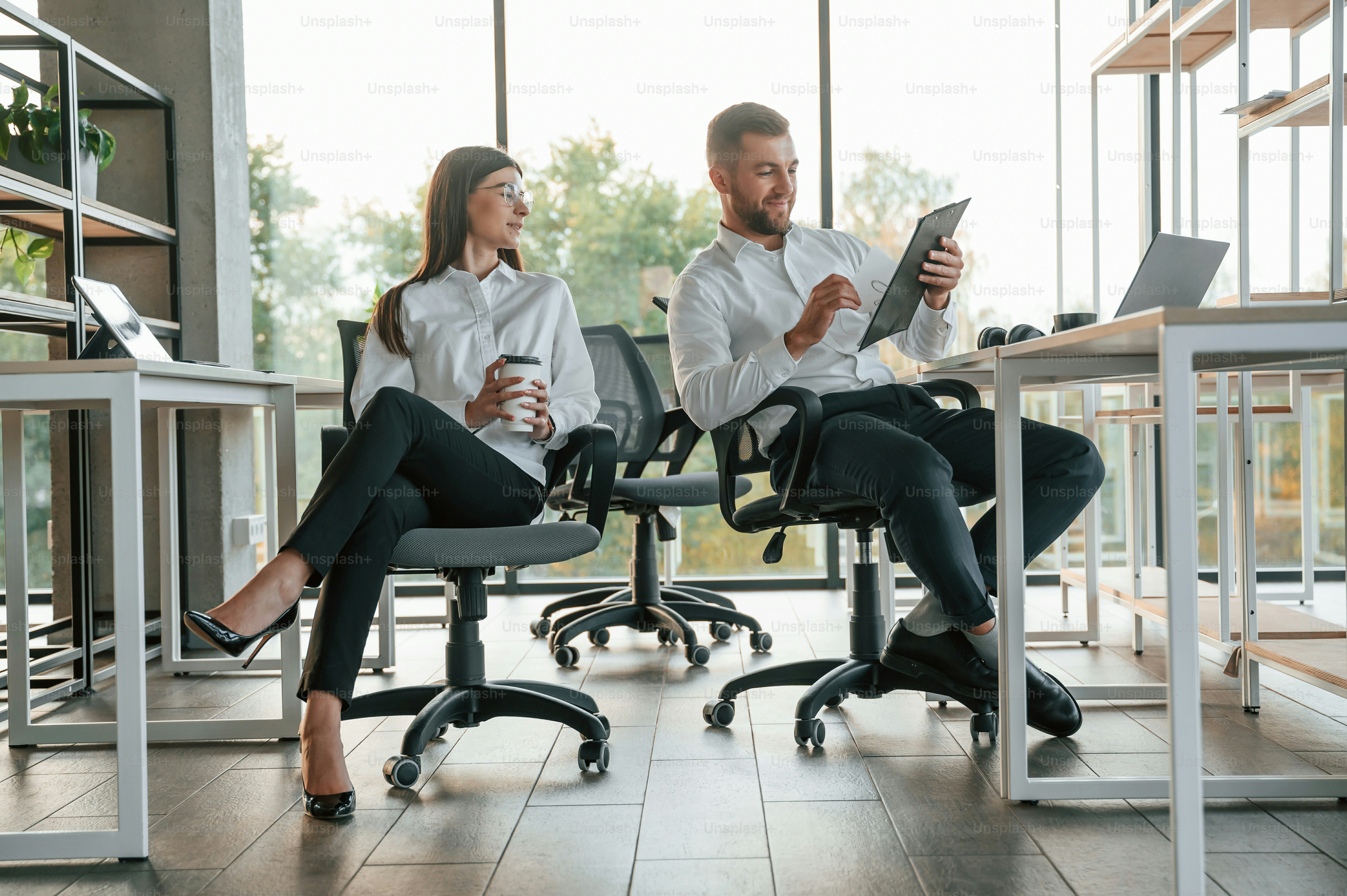 Parlarsi. L'uomo e la donna lavorano insieme nell'ufficio moderno.
