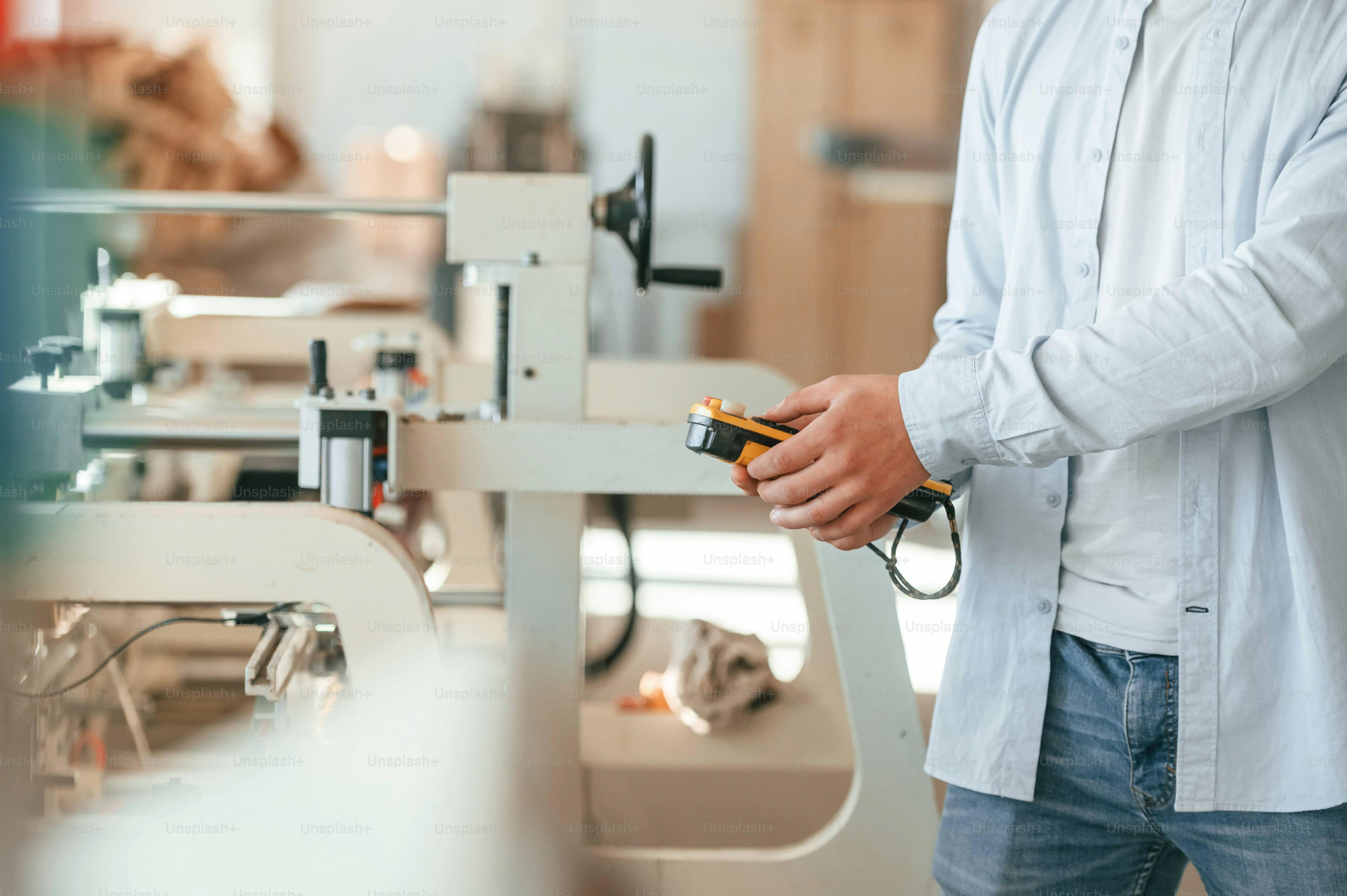 Modern printing machine. Typography worker in white clothes is indoors.