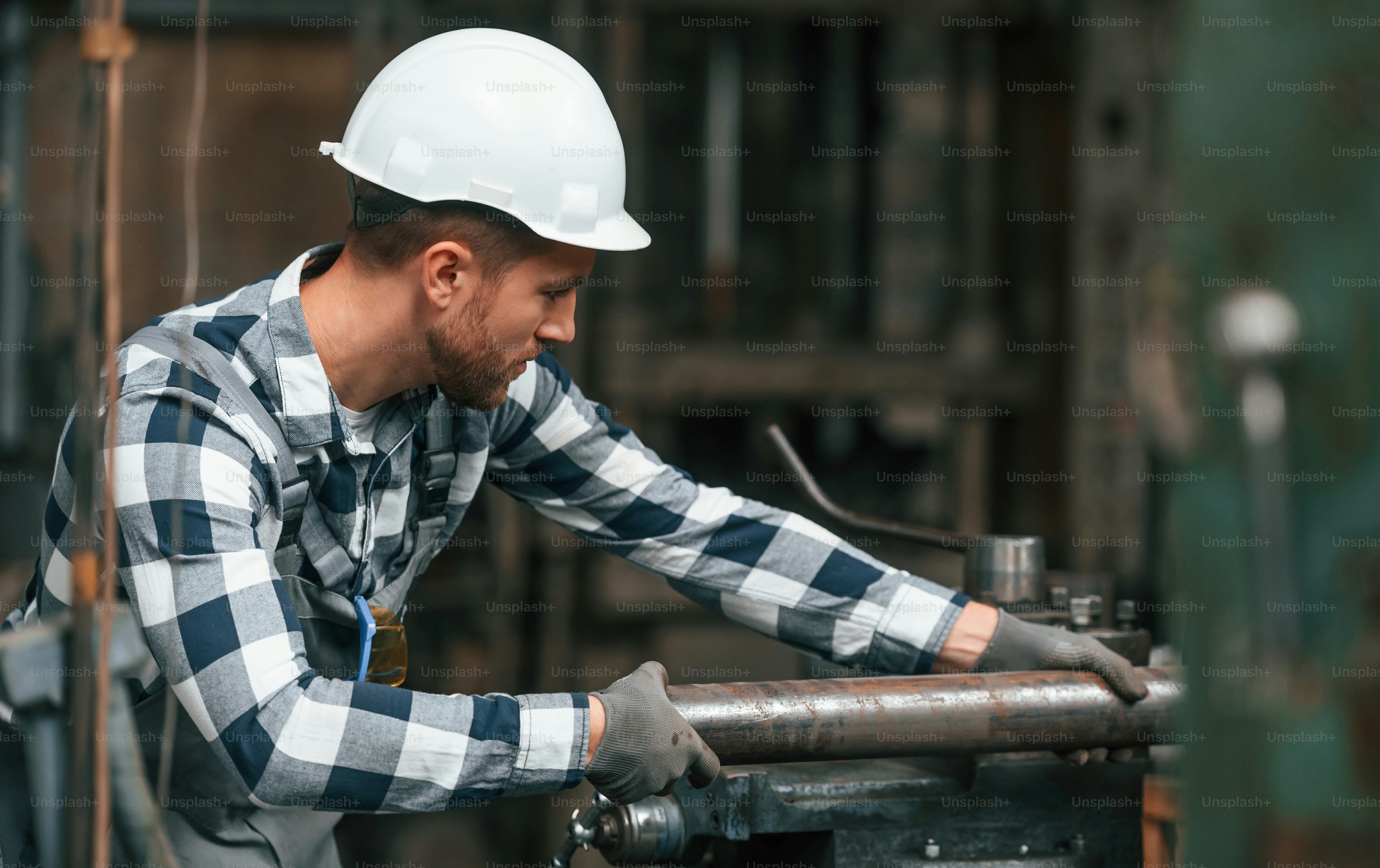 操作マシンによる作業。制服を着た工場労働者は屋内にいます。